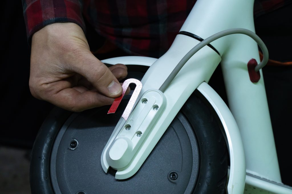 electric scooter repair workshop. the master holds in his hand the broken part of the scooter and motor wheel. replacing the tube and tires. modern environmentally friendly mode of transport.