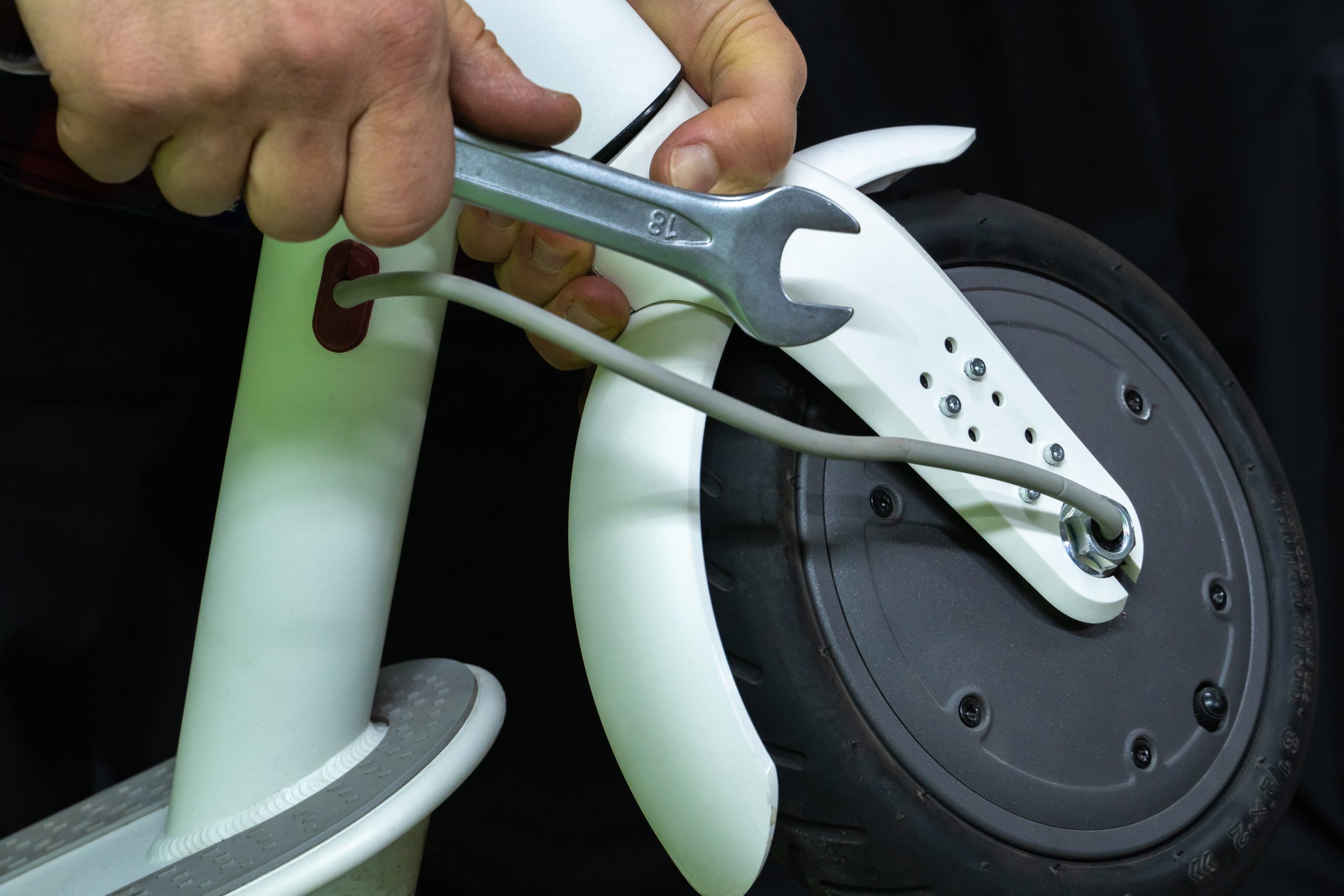 electric scooter repair workshop. the master holds in his hand the broken part of the scooter and motor wheel. replacing the tube and tires. modern environmentally friendly mode of transport.